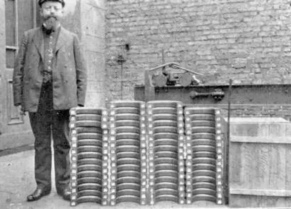 Historic photo of Gustav Espey standing beside early industrial sealing components.