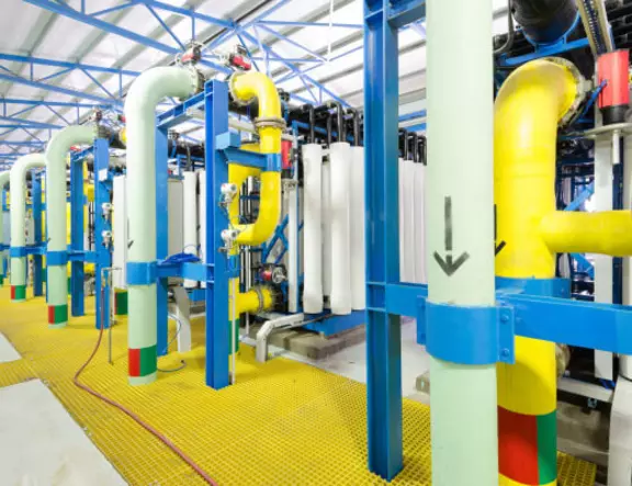 Industrial desalination plant with colorful high-pressure pipes and filtration units for water purification.