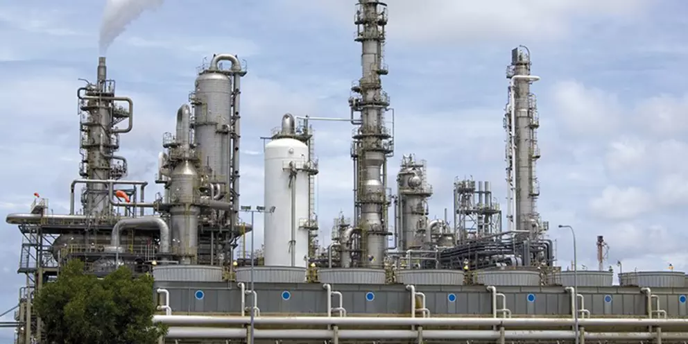 Ölraffinerie oder petrochemische Anlage mit Destillationskolonnen und Prozessausrüstung für industrielle Produktion und Energieerzeugung.