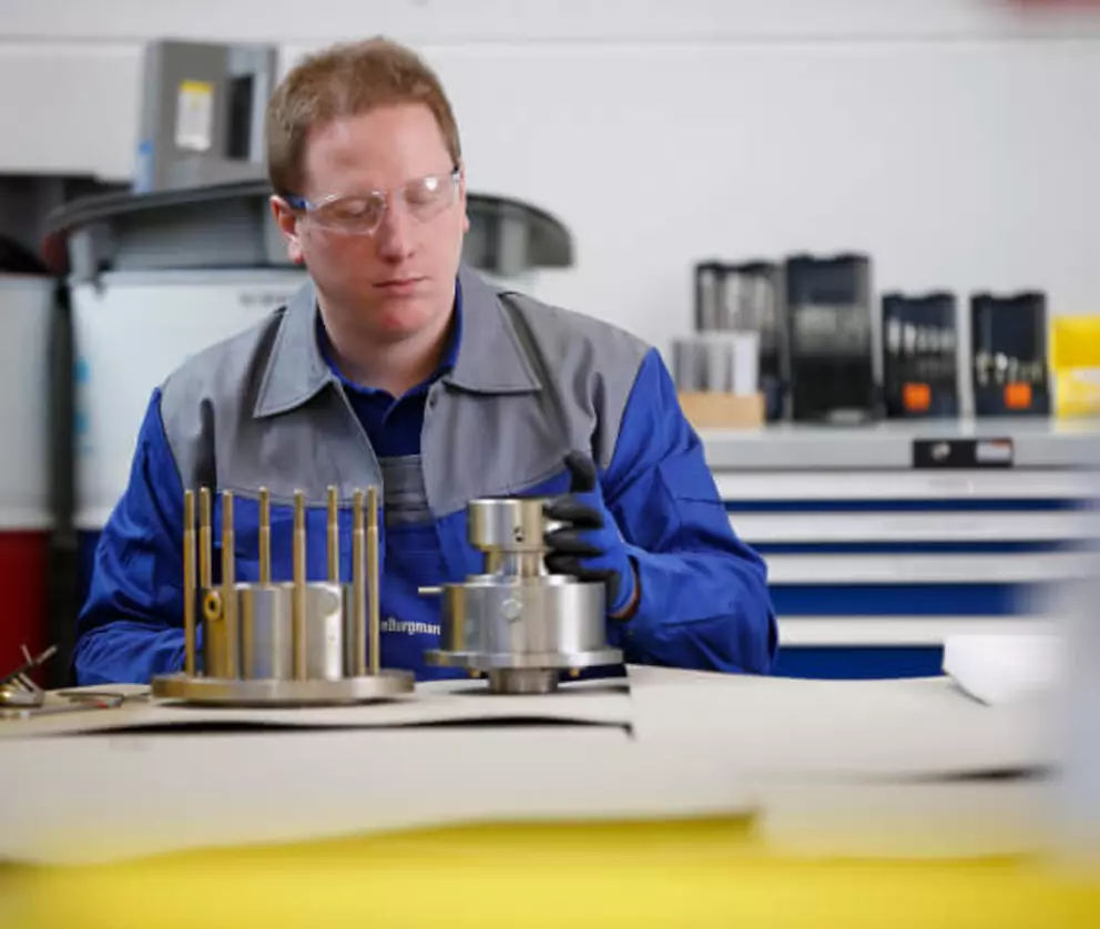 Ingenieur bei der Inspektion und Montage von präzisen Gleitringdichtungskomponenten in einer Werkstatt.
