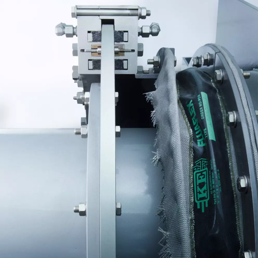 Industrial expansion joint installed on pipeline flange with fabric compensator for vibration isolation and thermal movement control.