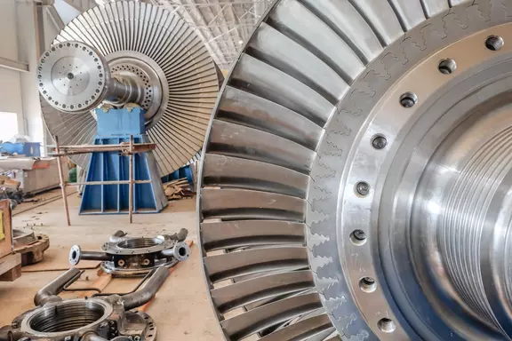 Steam turbine rotor and blade assembly in an industrial maintenance facility.