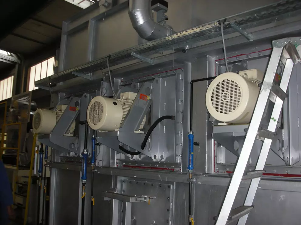 Industrial equipment module with electric motors and access ladder in a manufacturing facility.