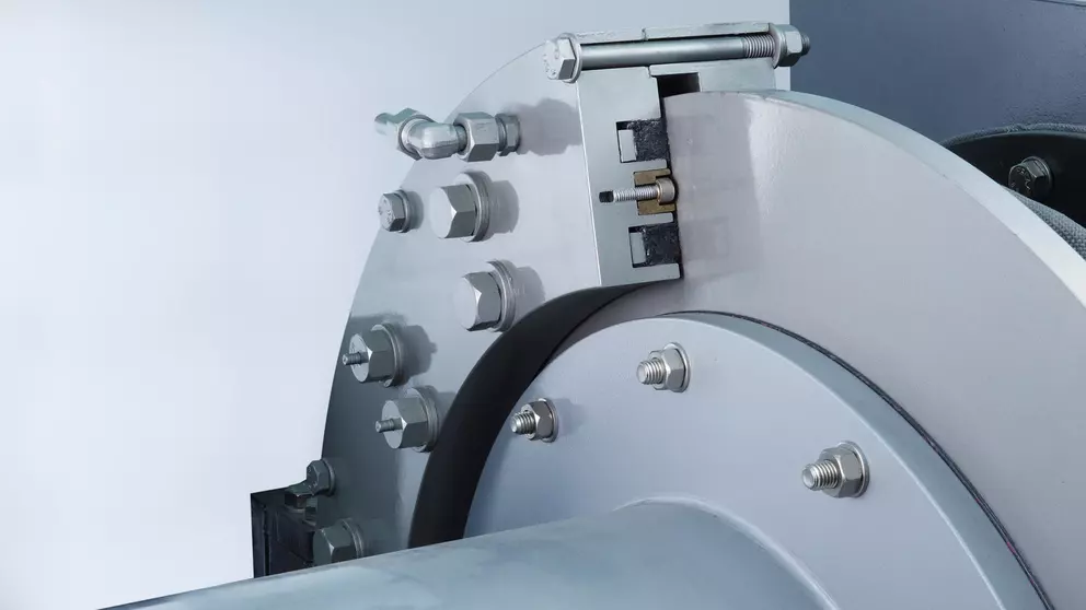 A close-up of a large, two-part metal industrial component that appears to be a dry gas seal, showing a radial cross-section secured by large bolts, with internal components visible through the opening.