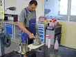 Egy EagleBurgmann-technikus egy műhelyasztalnál szerel vagy ellenőrzi egy mechanikus tömítés alkatrészét, szerszámok és szervizfelszerelések között, egy műszaki karbantartási környezetben.
