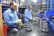 Technicians inspecting and assembling precision-machined industrial sealing components at a workshop bench, highlighting quality control, manufacturing accuracy, and technical expertise.