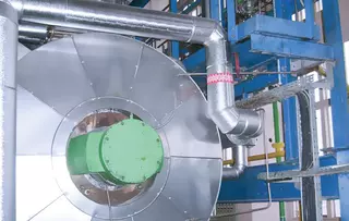 Close-up of an industrial system with insulated vessel and connected piping.