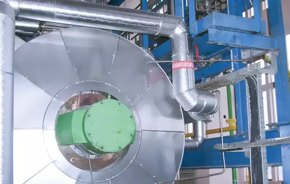 Close-up of an industrial system with insulated vessel and connected piping.