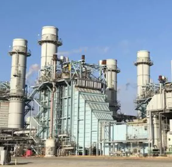 Industrial processing plant with large towers, structural piping, and heavy-duty equipment in an industrial facility setting.