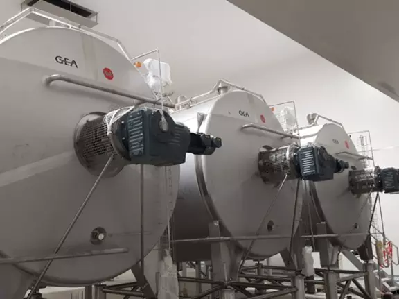 Stainless steel GEA industrial mixing tanks used in food and beverage production facilities.