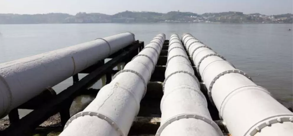 Large industrial water transport pipelines extending over a river for municipal and industrial water supply.