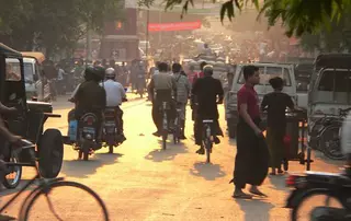 Belebte Straße in Indonesien mit Motorrädern und Fahrrädern – veranschaulicht die Sicherheitsinitiative von EagleBurgmann, bei der Mitarbeitern Helme zur Verfügung gestellt werden, um Kopfverletzungen bei Verkehrsunfällen zu verhindern.