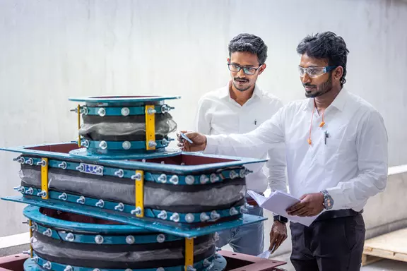 Engineers inspecting industrial expansion joints and flexible connectors to verify quality, fit, and performance for piping systems.