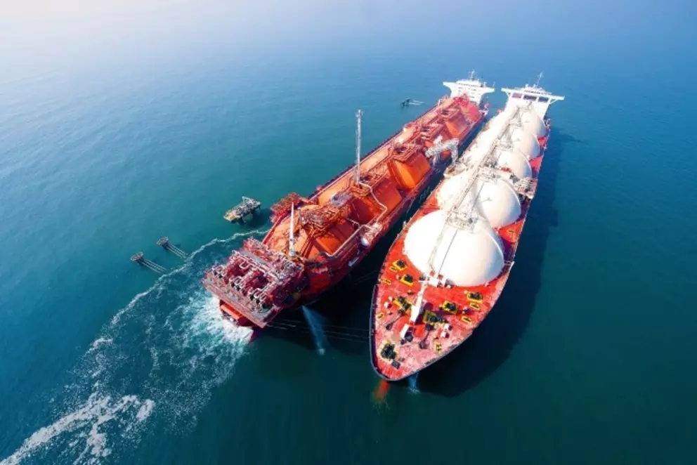Two LNG carriers performing ship-to-ship transfer operation at sea for liquefied natural gas transport and distribution.