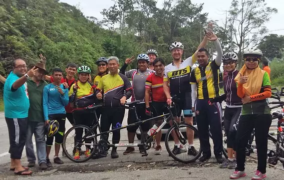 Mitarbeiter von EagleBurgmann Malaysia und sehbehinderte Teilnehmende posieren mit Tandemfahrrädern während einer Gemeinschaftsradveranstaltung, die Inklusion und Teamarbeit fördert.