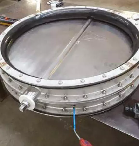 Round metal expansion joint with integrated flange and actuator connection for precise movement control in industrial ducting and process systems.