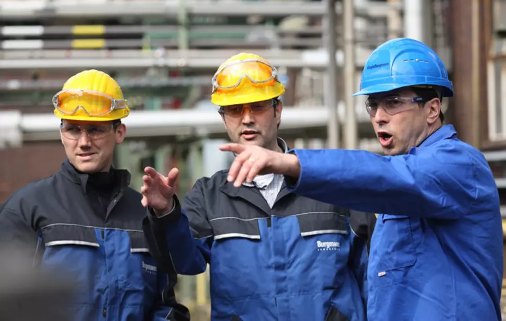 Ingenieure und Fachkräfte besprechen Sicherheits-, Wartungs- und Prozessabläufe in einer industriellen Produktionsanlage.