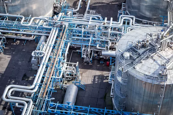 Aerial view of industrial storage tanks and interconnected pipelines at a Chemical processing plant.