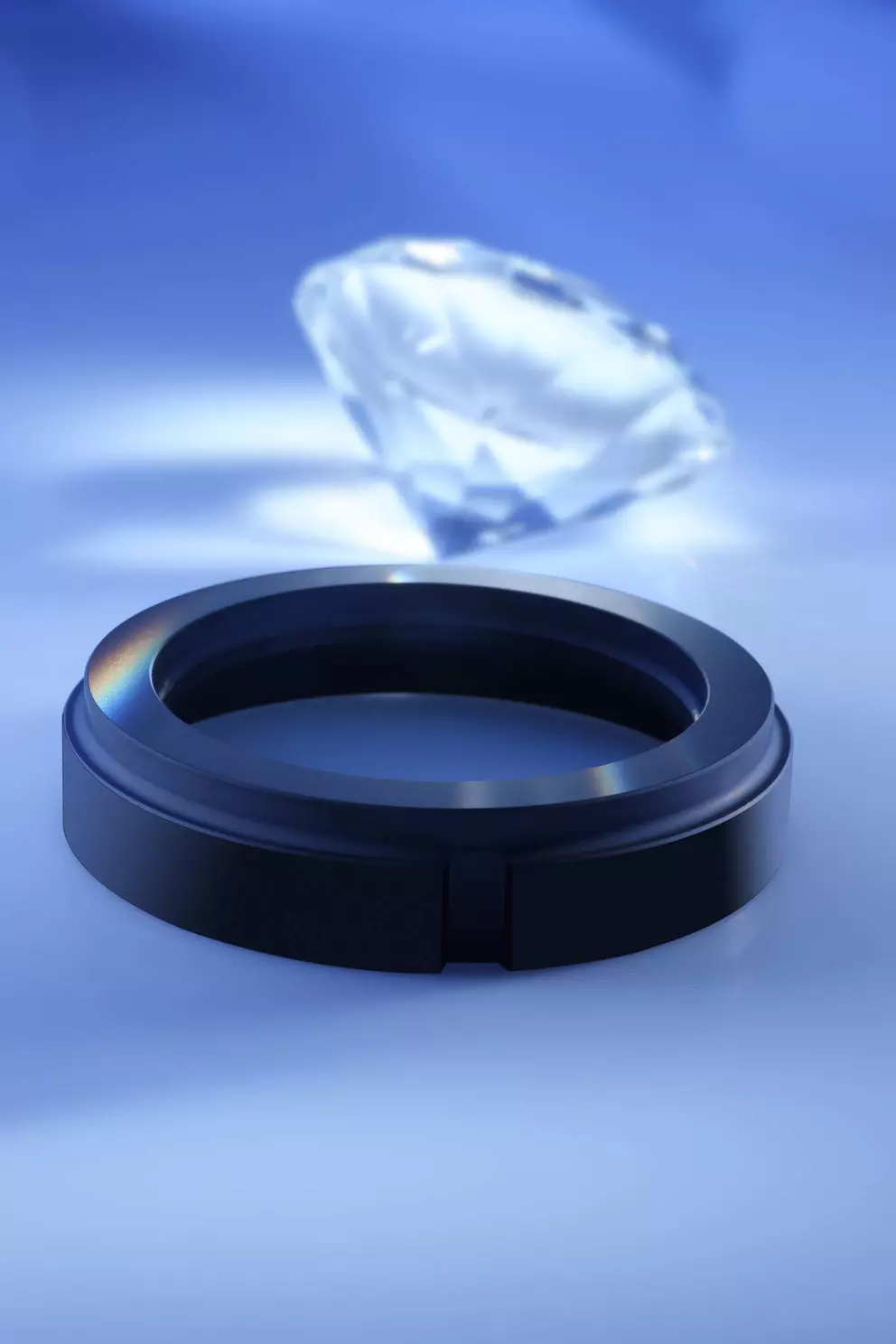 Eine dunkle, ringförmige Komponente, möglicherweise eine Dichtung oder ein Lagerring, im Vordergrund mit einem großen, facettierten Diamanten, der im Hintergrund verschwommen ist, vor einem blauen Farbverlauf.
