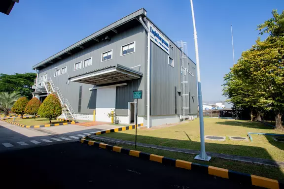 EagleBurgmann industrial facility with modern metal-clad exterior, loading area, and landscaped grounds under a clear blue sky.