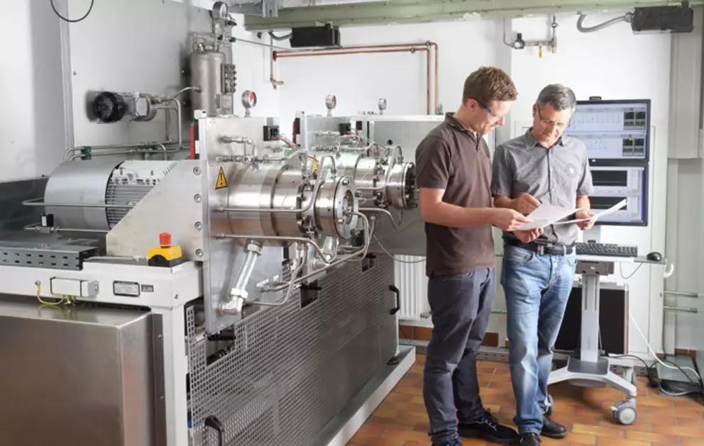 Ingenieure analysieren Prüfergebnisse an einer industriellen Testanlage zur Optimierung von Dichtungstechnologien und Qualitätssicherungsprozessen.