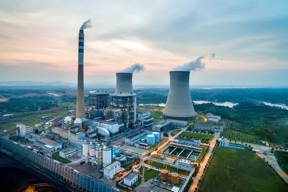Aerial view of a modern power plant facility with cooling towers and industrial infrastructure for efficient energy generation and environmental sustainability.