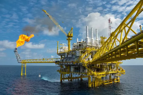Offshore oil and gas platform with burning flare stack, illustrating energy production, industrial engineering, and sustainable operations in the oil and gas industry.