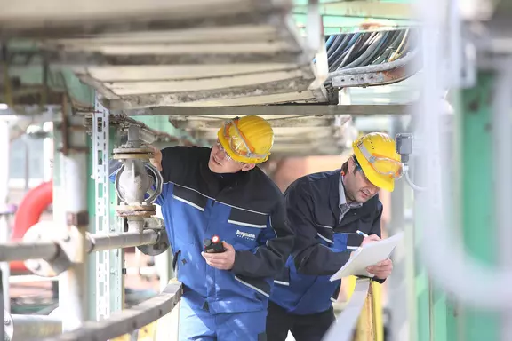 Two technicians performing maintenance on an industrial process plant