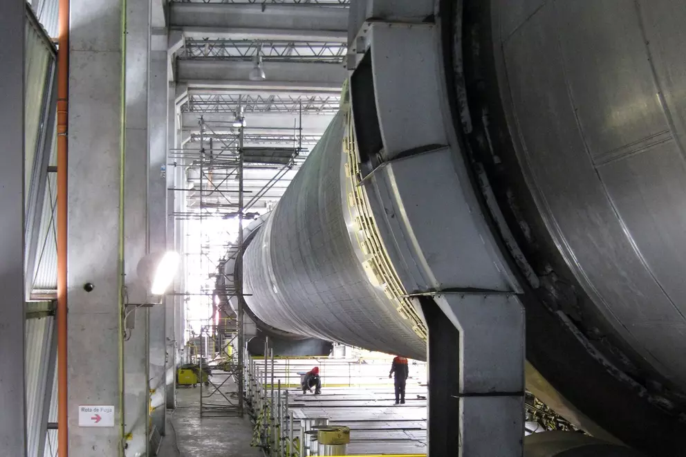 Large industrial rotary drum inside a processing facility.