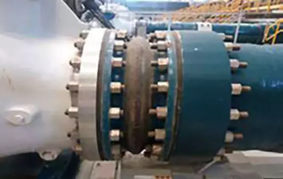 Rubber expansion joint installed between industrial pipeline flanges for vibration damping, movement compensation, and stress reduction in piping systems.