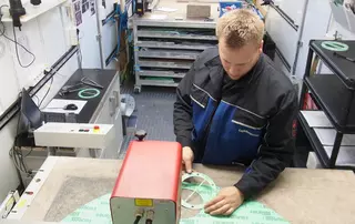 Techniker fertigt präzise Dichtungskomponenten in einer Werkstatt mithilfe von Spezialmaschinen an.