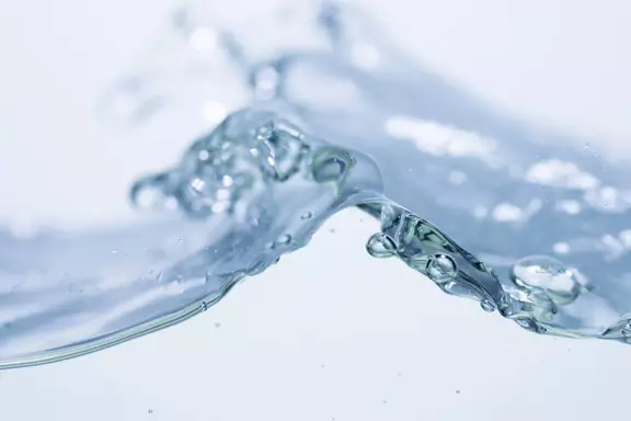 Close-up of clear water flow symbolizing purity and fluid dynamics – representing sealing technology for liquid processing applications.