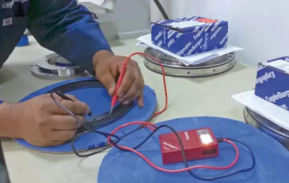 Techniker führt eine elektrische Messung an einem Präzisionslagerring mit einem Prüfgerät durch.