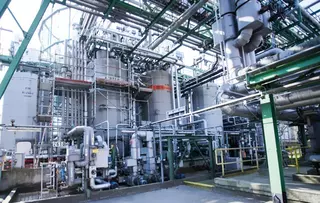 Industrial plant with vessels, piping, and process systems.