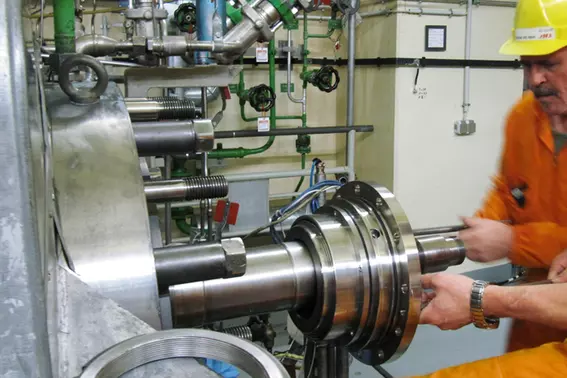 Technician installing a mechanical seal on industrial rotating equipment in a power plant, illustrating on-site maintenance and service for critical machinery.