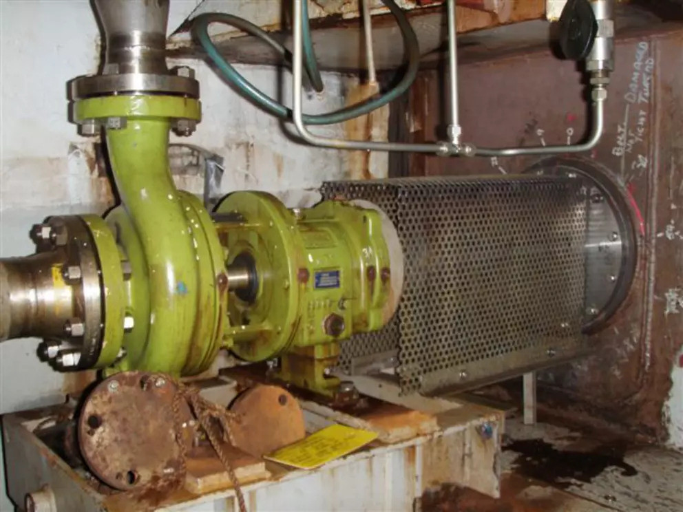 Industrielles Pumpensystem mit Schutzabdeckung der Kupplung in einer Anlagenumgebung.