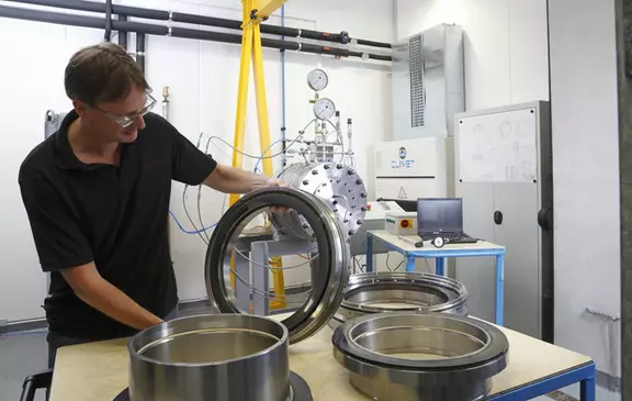 Techniker inspiziert große Präzisionsringe in einem industriellen Prüflabor.