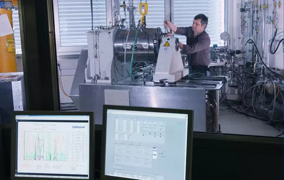 Techniker testet mechanische Dichtungen auf einem industriellen Prüfstand – überwacht aus dem Kontrollraum mit Live-Datenvisualisierung und Prozessanalyse.