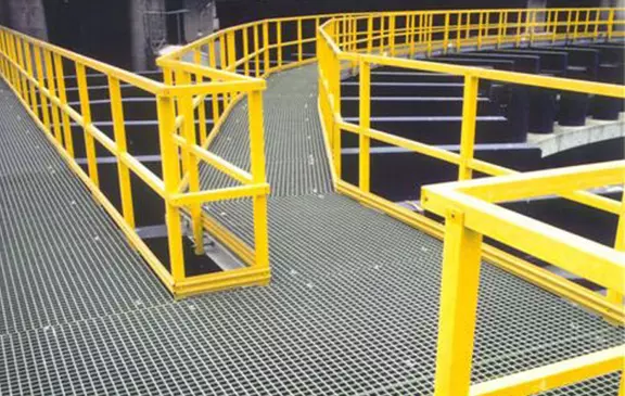 Industrial walkway with yellow safety railings and grating platform in a plant facility.