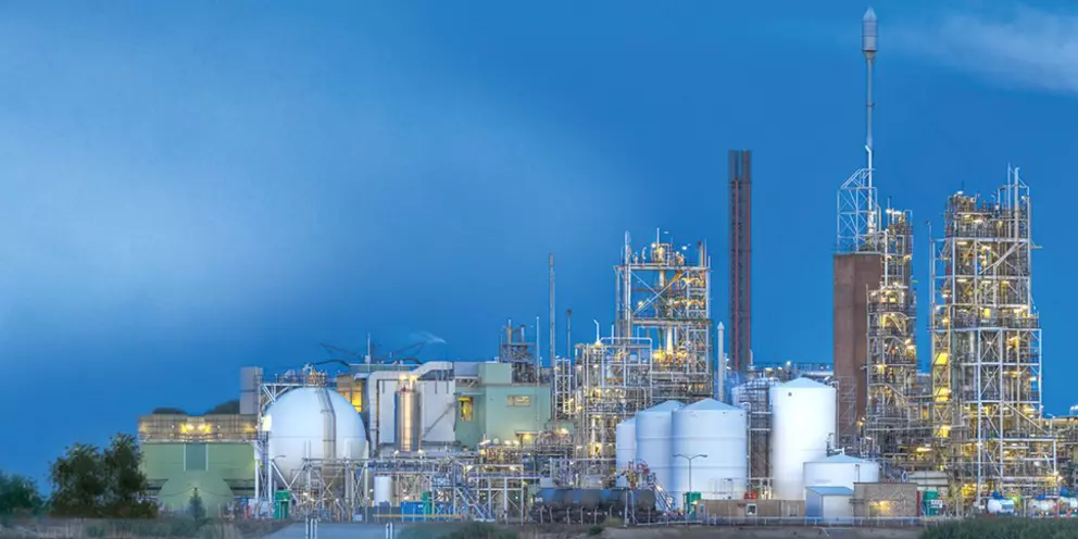 Chemieindustrieanlage mit Lagertanks und Prozesseinheiten in der Dämmerung, passend für Inhalte zu Energie, Petrochemie oder Raffineriebetrieb.