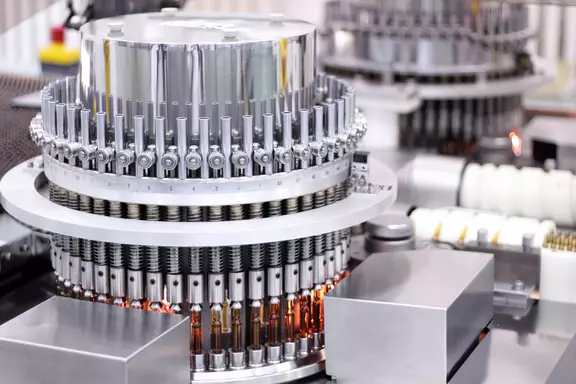 High-precision pharmaceutical filling and sealing machinery used for sterile production of medical vials and ampoules in a cleanroom environment.