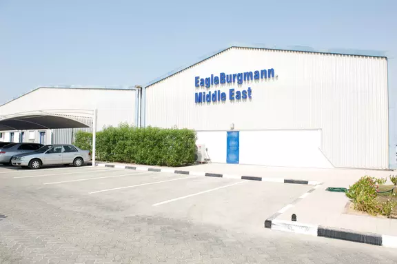 EagleBurgmann Middle East facility with company signage, parking area, and industrial buildings under a clear sky.
