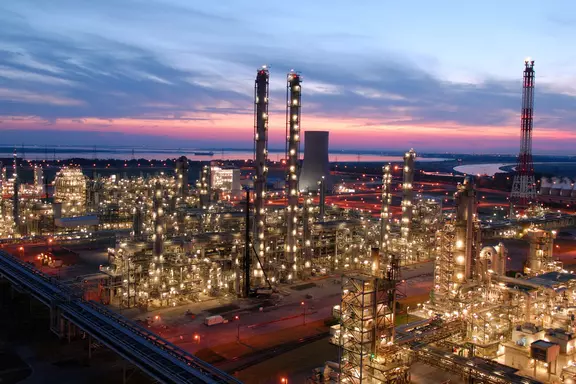 Petrochemical plant at dusk with illuminated towers and processing units, representing large-scale industrial applications in the petrochemical industry.