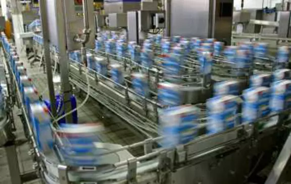 High-speed beverage bottling line in a food processing plant, showing automated conveyor systems for efficient packaging and production.