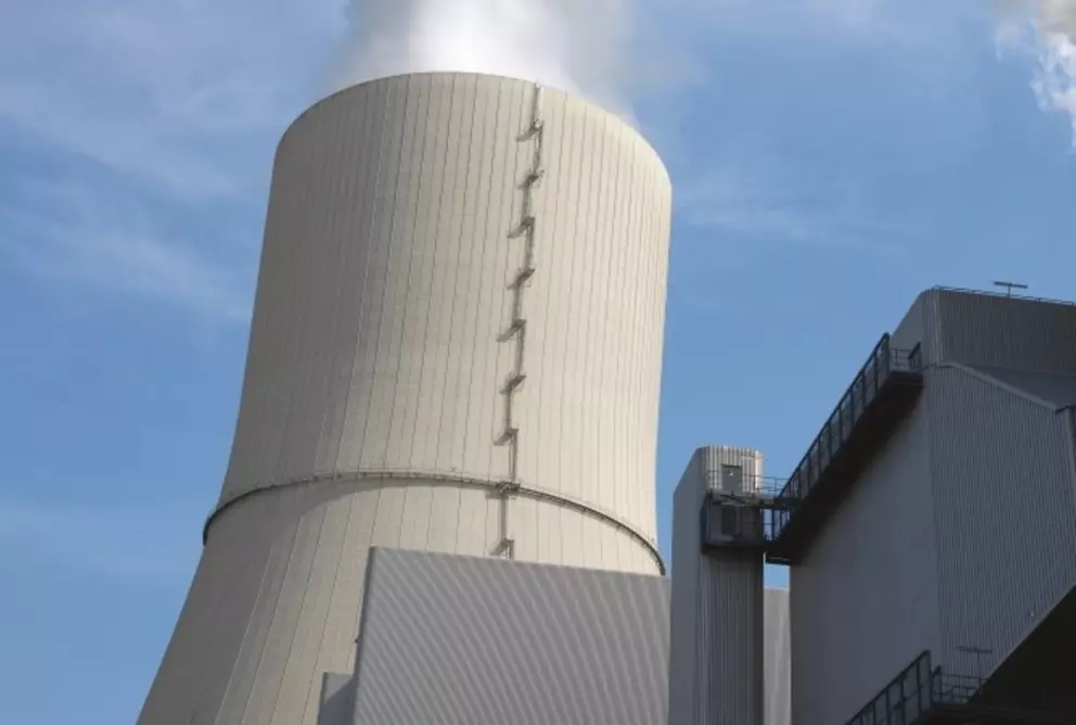 Cooling tower of an industrial power plant emitting steam into the sky.