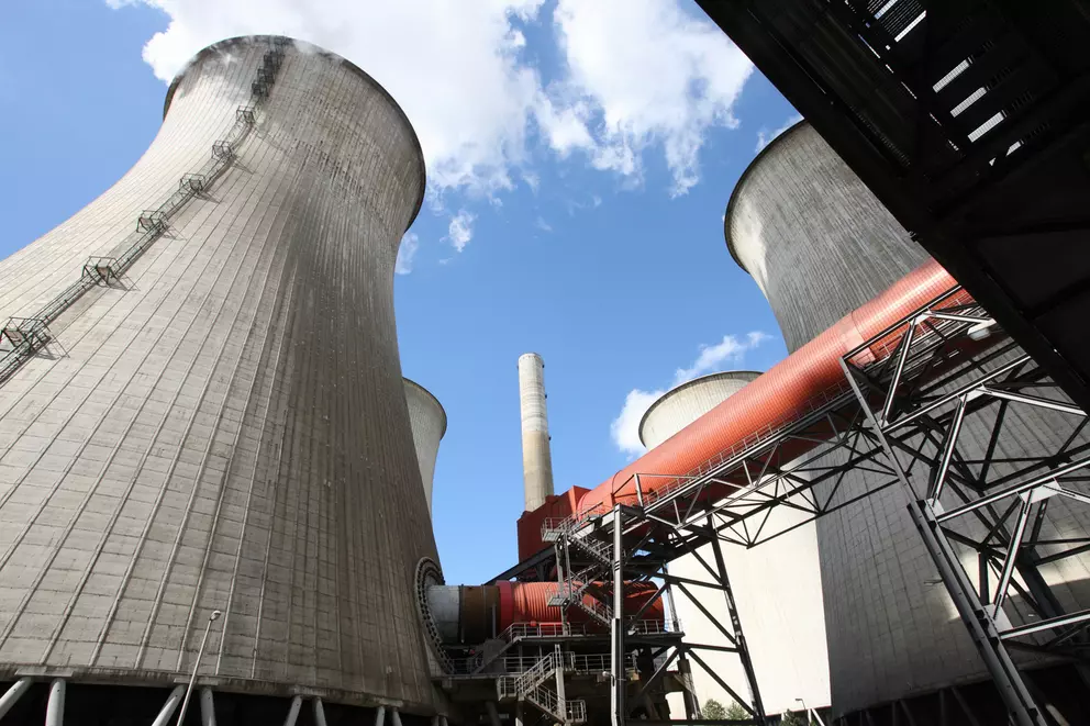 Cooling towers and industrial piping at a power plant facility.