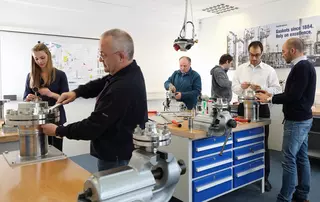 Mitarbeiter montieren und prüfen mechanische Dichtungen in einem modernen Schulungs- und Trainingsraum.