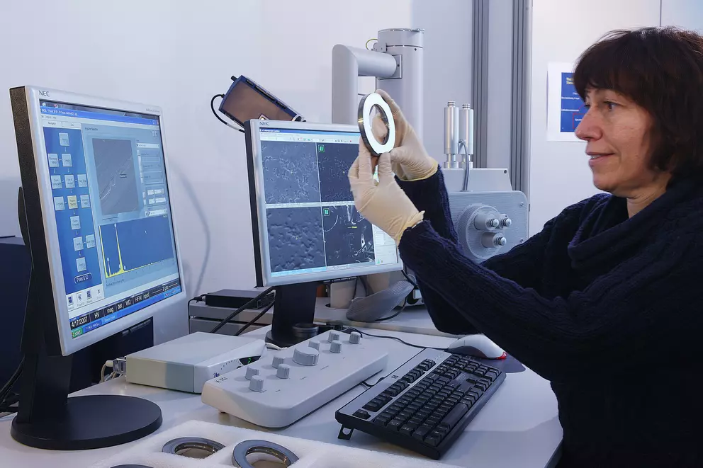 Mitarbeiterin untersucht eine industrielle Dichtungskomponente mit hochauflösender Mikroskopie und digitaler Materialanalyse zur Qualitätssicherung und Schadensbewertung.