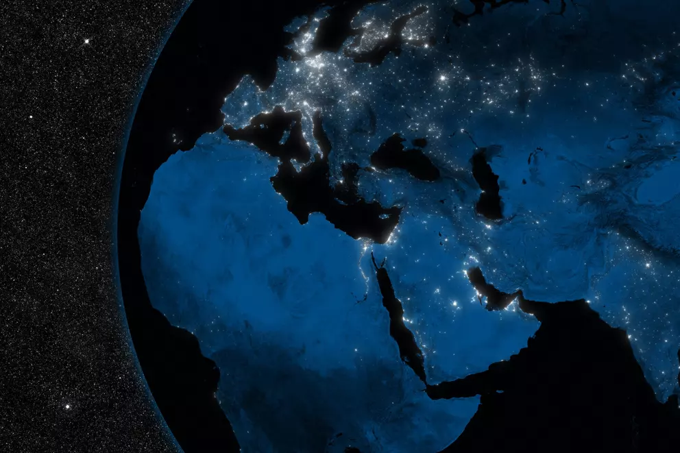 Satellitenansicht von Europa, Afrika und dem Nahen Osten bei Nacht mit sichtbarer urbaner Infrastruktur und globaler Vernetzung.