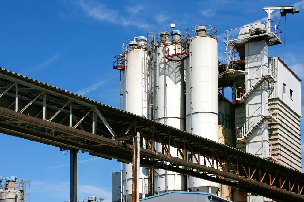 Industrieanlage mit Lagersilos, Förderkonstruktion und Prozessturm.